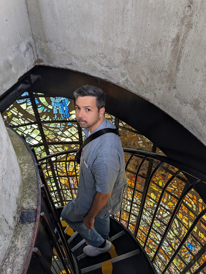 Paul O’Rourke on a spiral staircase lit by stained glass